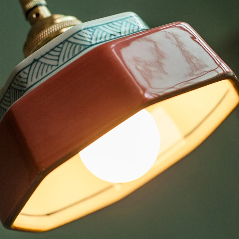 Red pendant light hanging against a green wall